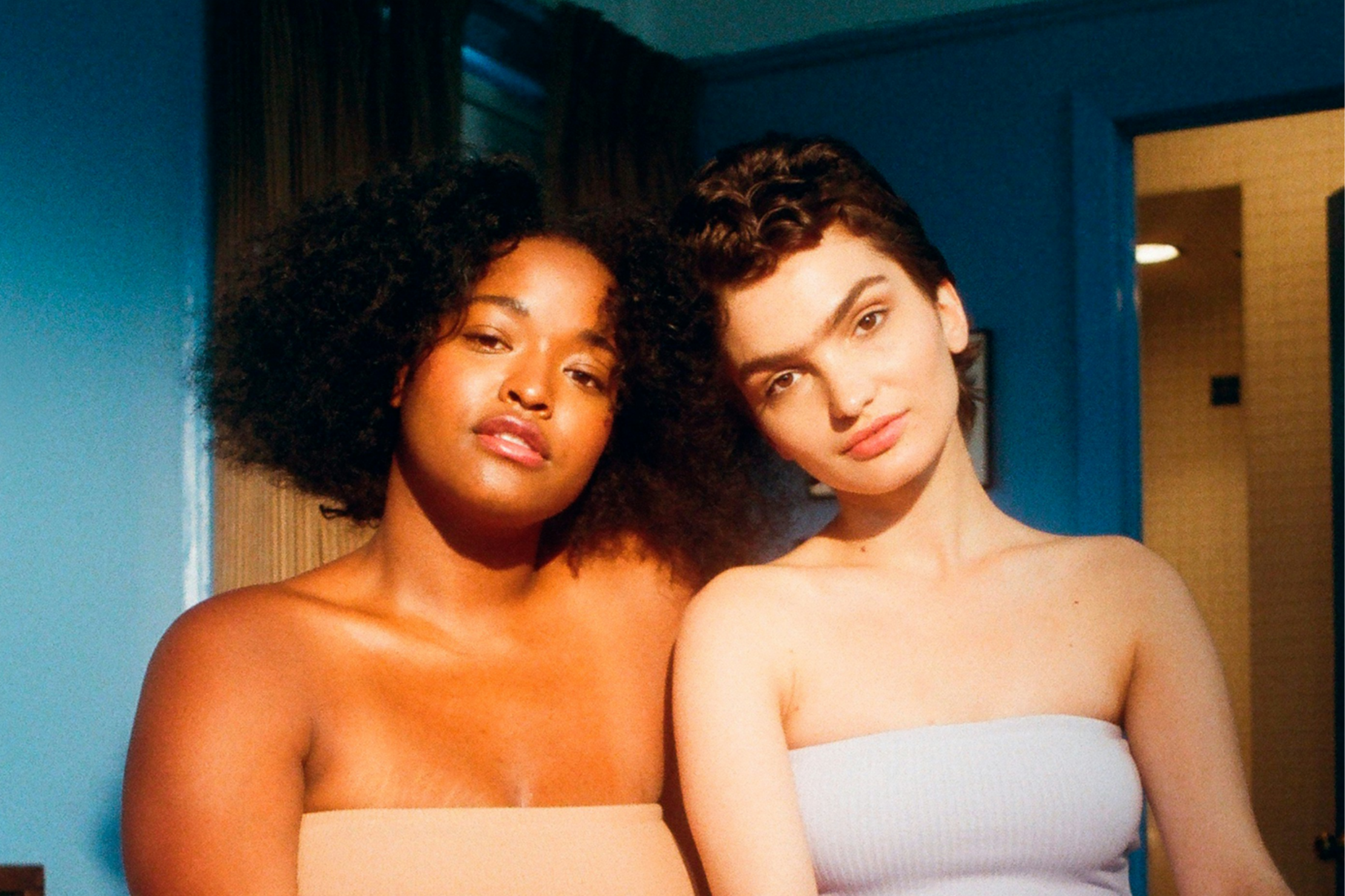 Two friends sit close together, illustrating the importance of friendship for aromantic people and the aromantic spectrum.