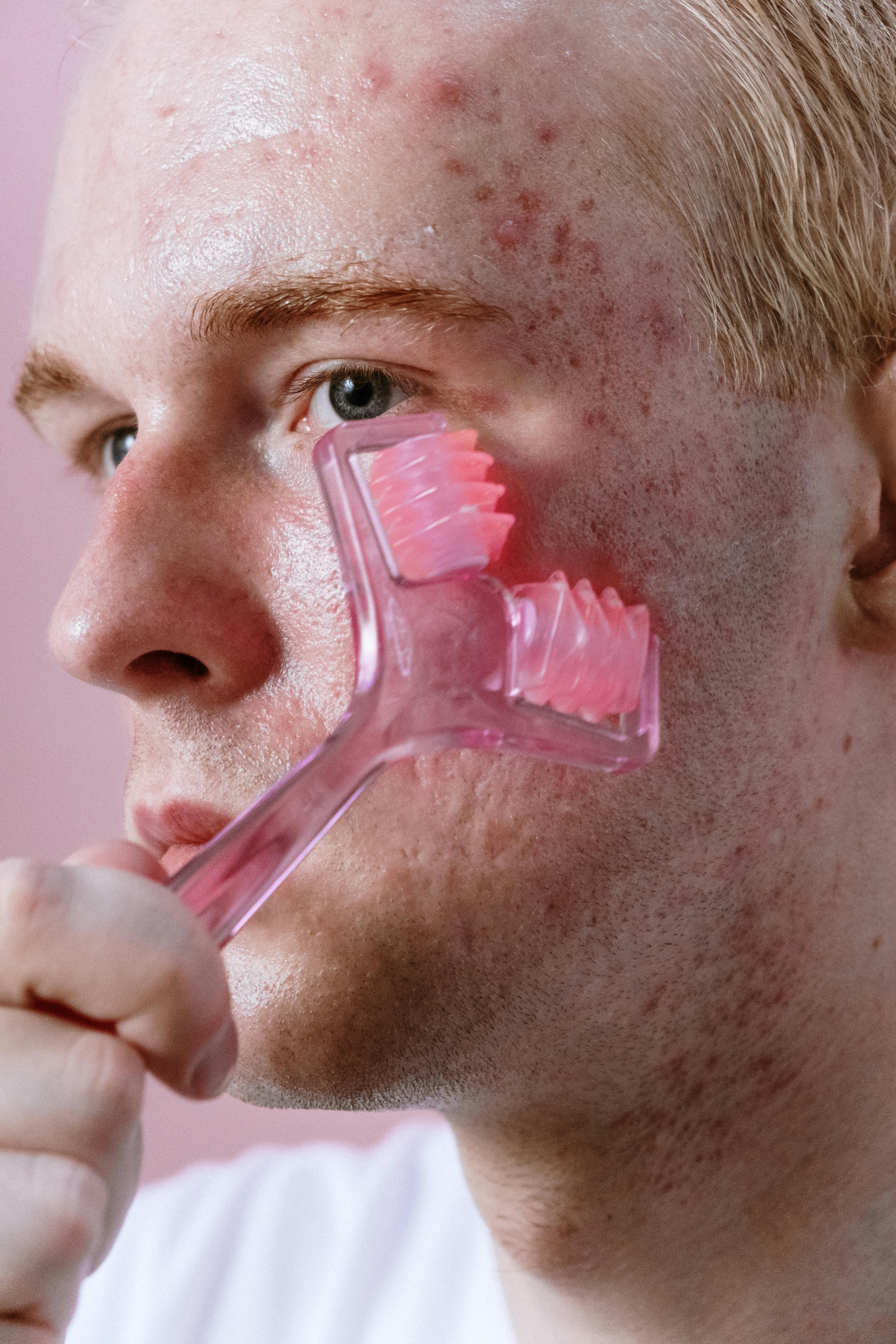 A man massaging his face with a face roller, embracing self-Care and love