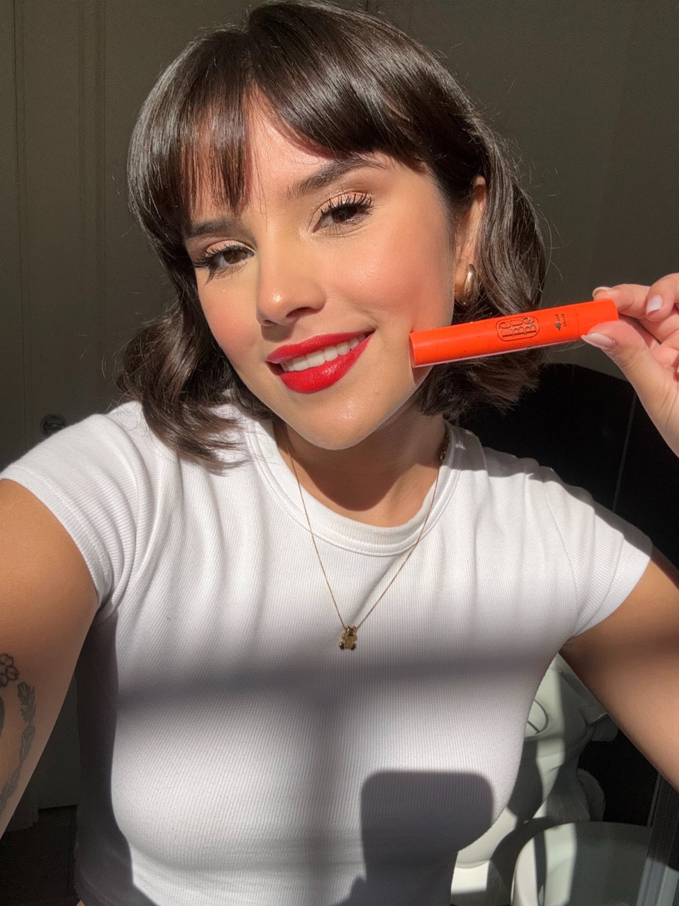 Woman wearing skncare-powered Lip and Cheek in Fiery Red, with a bold look on her lips. From Lebubè natural hybrid cosmetics