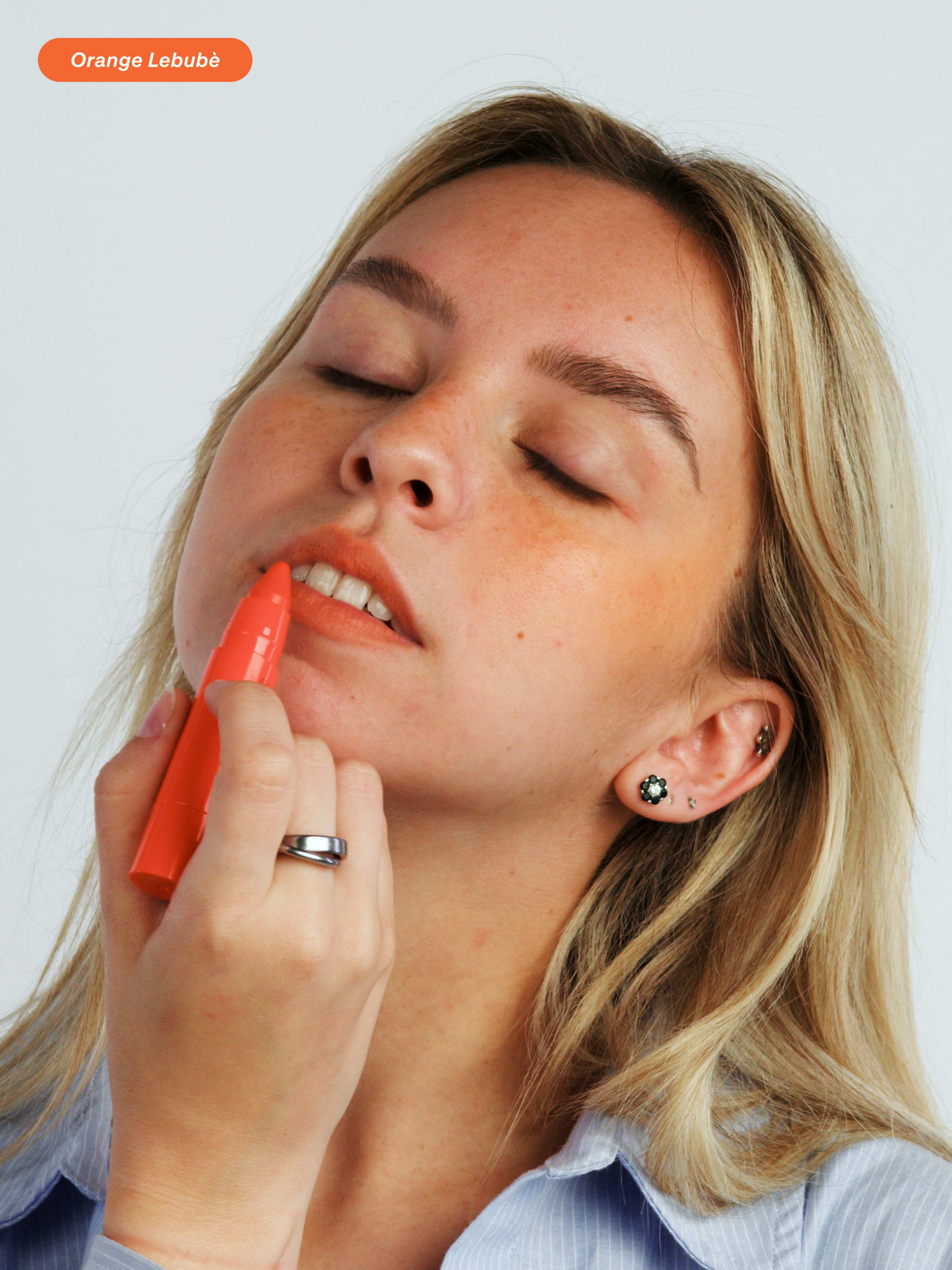 Woman applying the 2 in 1 blush and lipstick in Orange: perfect for summer, sun-kissed lips and a natural look