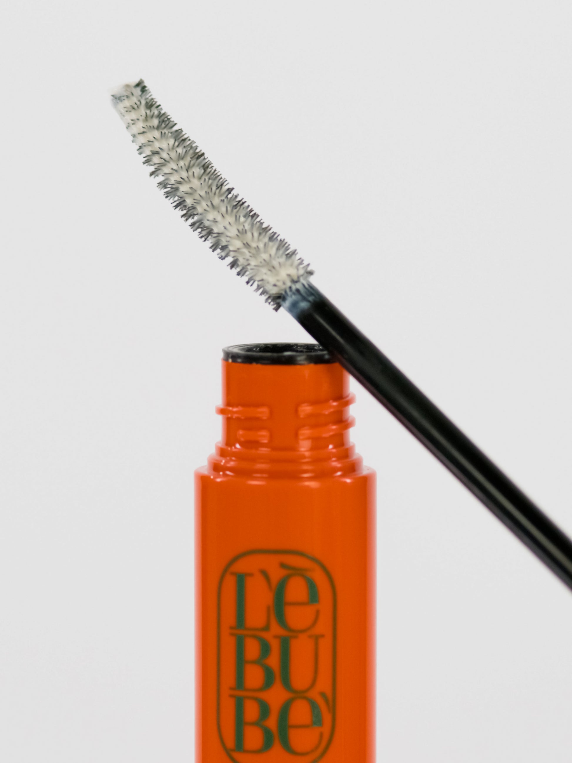 Lebubè Lash Primer and Overnight Mask: lash volume booster and natural lash primer. Brush zoomed in, resting on the tube.