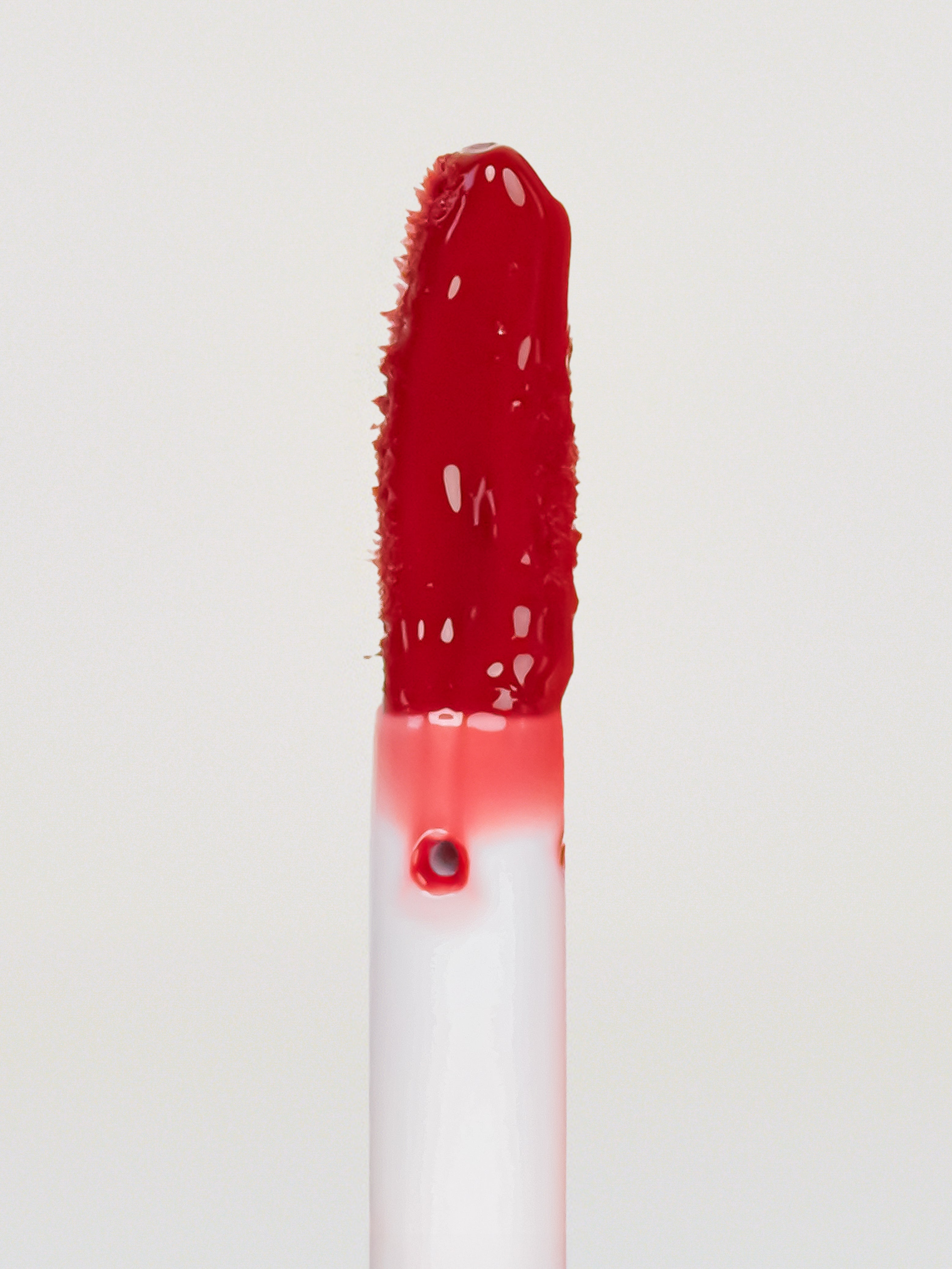 Lebubè Tinted Lip Oil and Balm Pomegranate, focus front view of the brush. Vegan, hydrating, repairing lip treatment for dry lips.