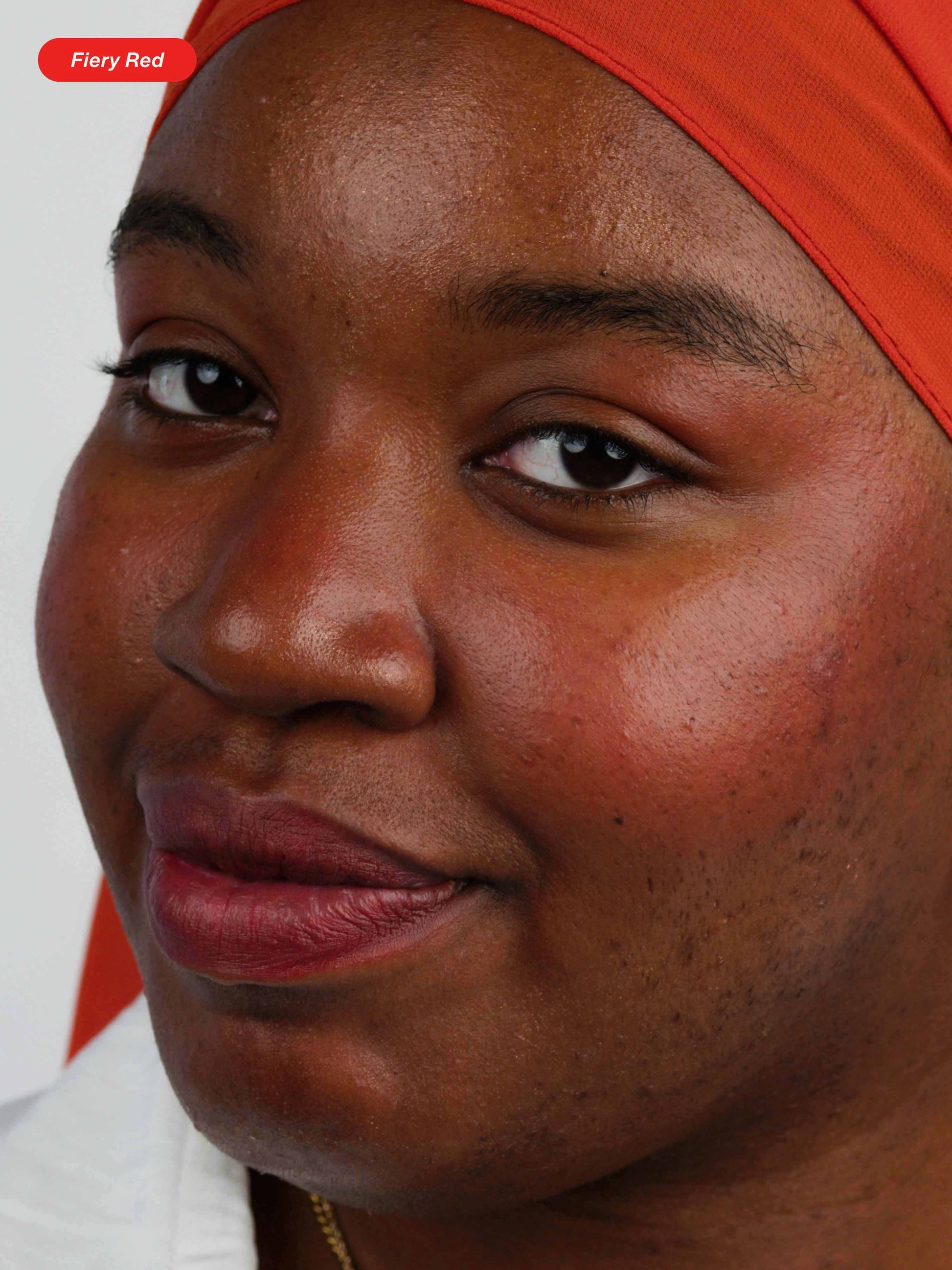 Woman wearing Lebubè multifunctional vegan and Halal lipstick and blush with natural ingredients in Fiery Red, with bold look