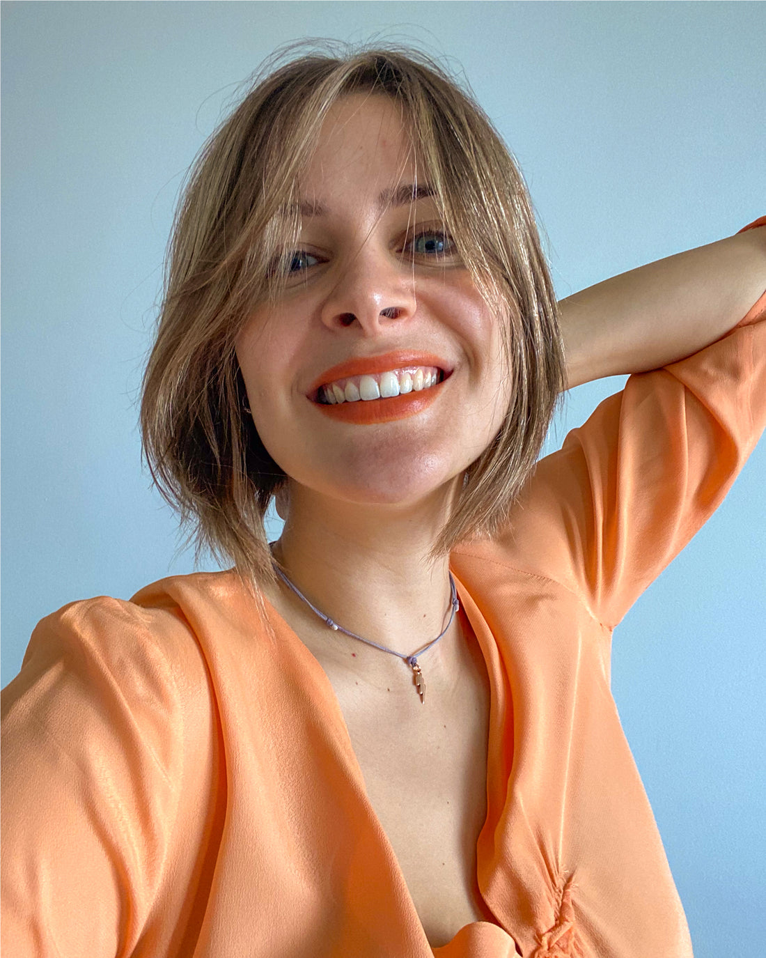 Woman wearing Lebubè vegan 2 in 1 orange blush and lipstick on her lips, for a sun-kissed look and sunset blush effect
