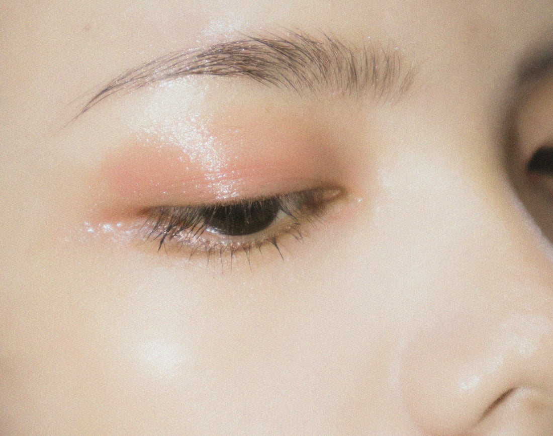 Woman with flawless makeup, glass-skin and sparkly eyeshadow, showing the psychology behind makeup and why we wear makeup