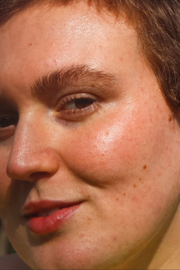 Close-up of a woman wearing vegan orange blush and hydrating cream highlighter for sunset blush effect and sun-kissed effect