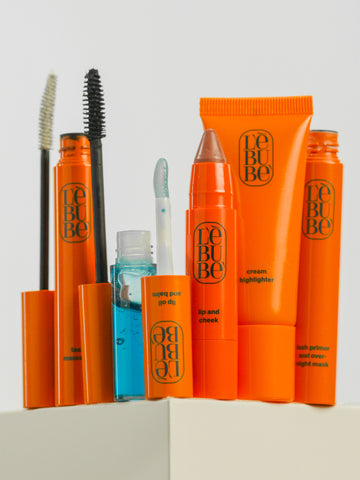 Five Lebubè hybrid cosmetics part of a makeup set: lip and cheek, lip oil, highlighter, lash growth treatment and mascara