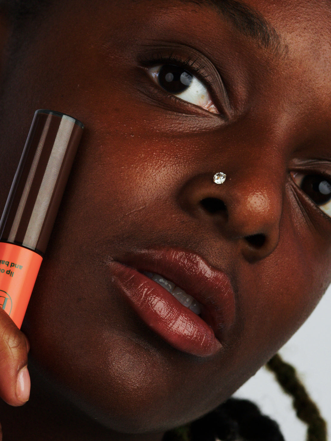 Woman wearing the brown lip oil for glossy and hydrating finish in Bitter Chocolate, from Lebubè natural hybrid cosmetics