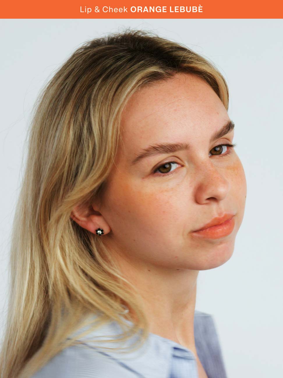 Woman applying the 2 in 1 blush and lipstick in Orange: perfect for summer, sun-kissed lips and a natural look