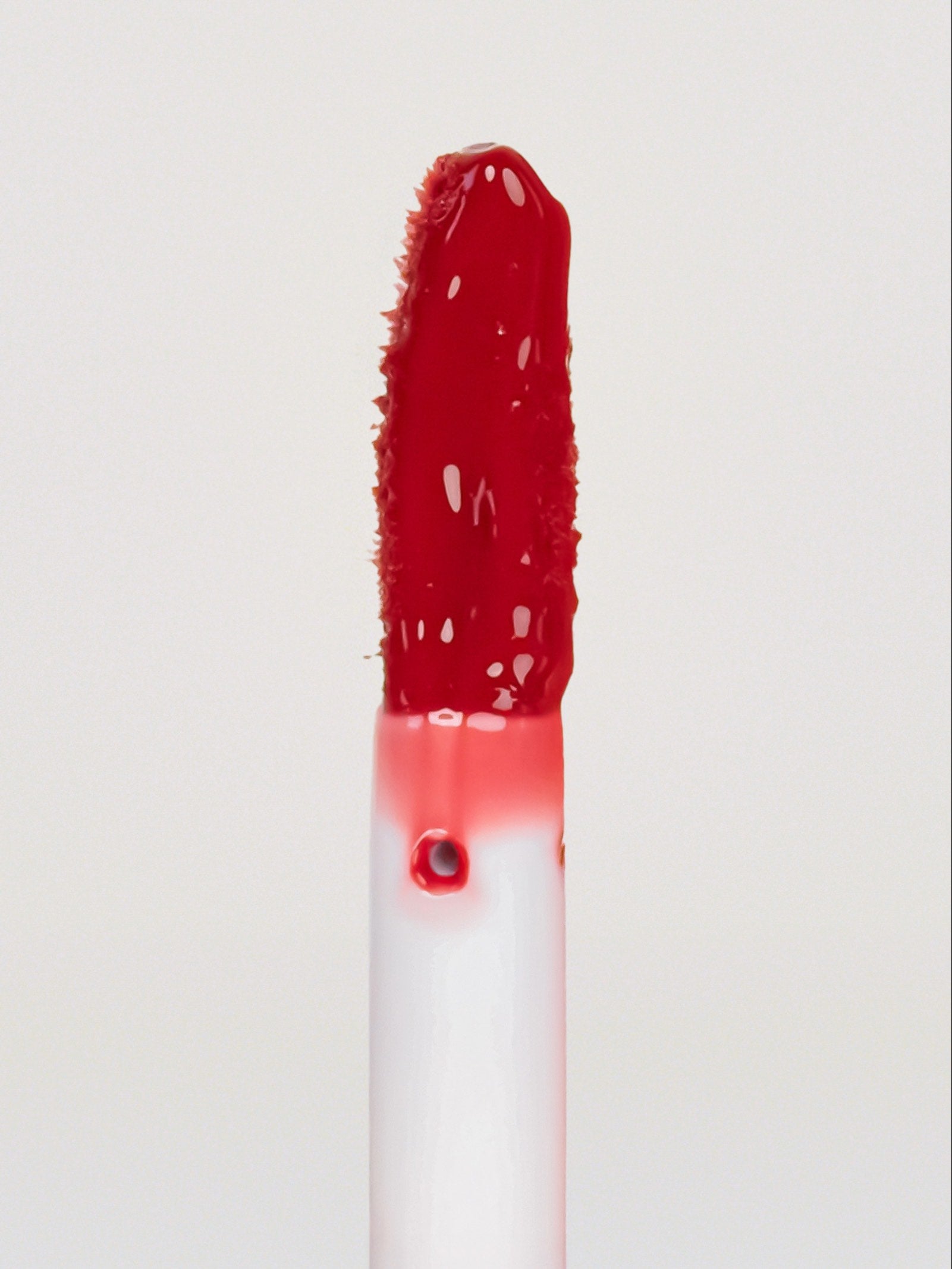 Lebubè Tinted Lip Oil and Balm Pomegranate, focus front view of the brush. Vegan, hydrating, repairing lip treatment for dry lips.