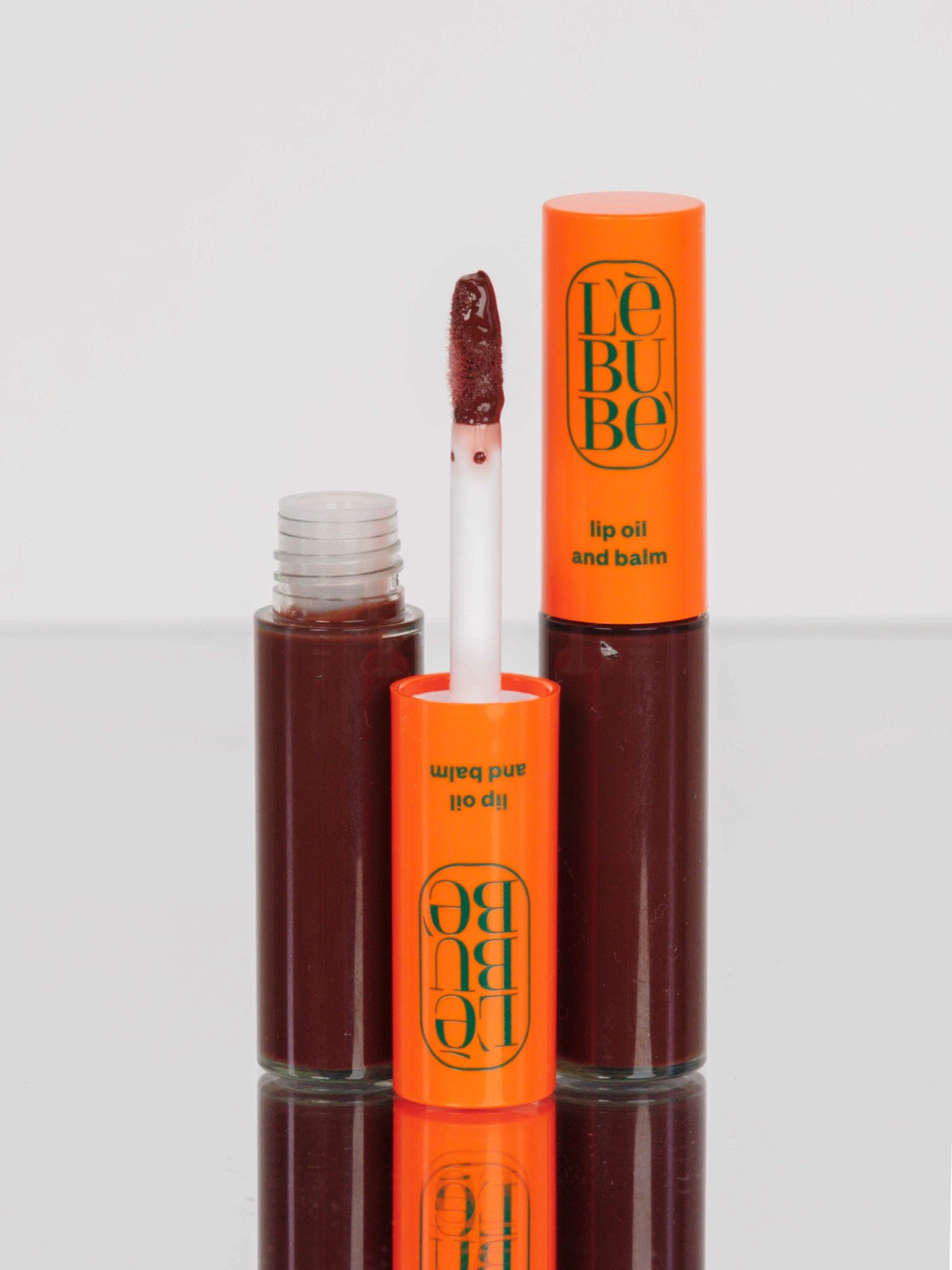 Lebubè Tinted Lip Oil and Balm: zoomed-in front view of Bitter Chocolate shade. Plumping brown lip oil for a warm, nude look