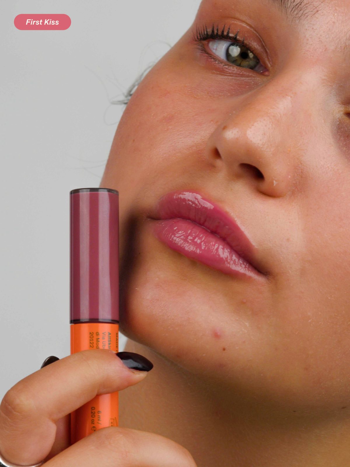 Close-up of lips wearing Lebubè Tinted Lip Oil and Balm in the First Kiss shade, with the lip treatment near the woman's face
