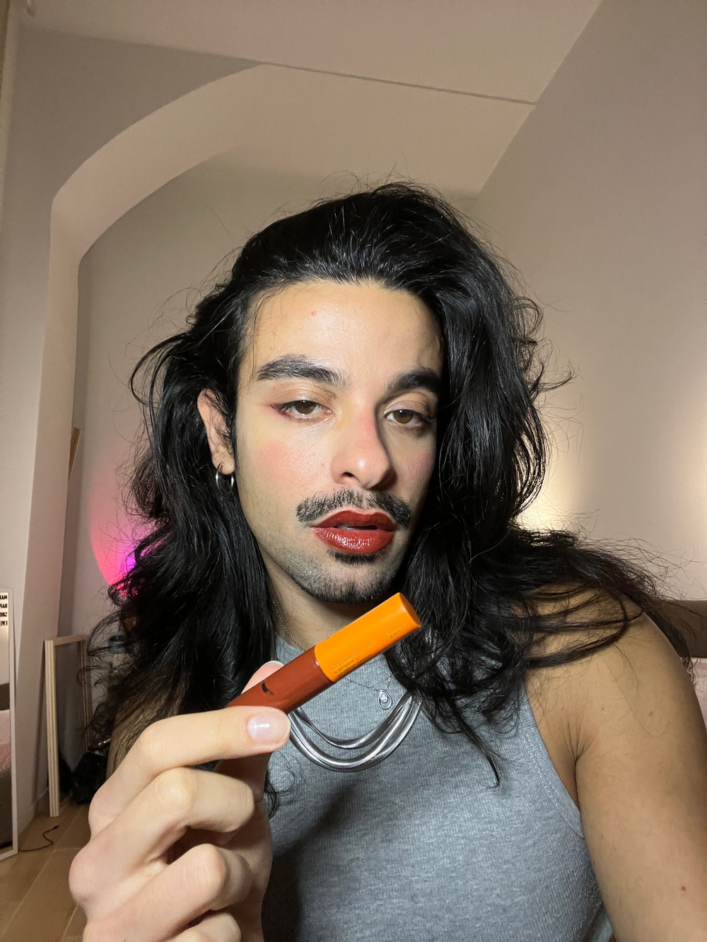 Man wearing vegan Tinted Lip Oil and Balm in Pomegranate for hydrated, glossy, tinted lips. From Lebubè hybrid cosmetics