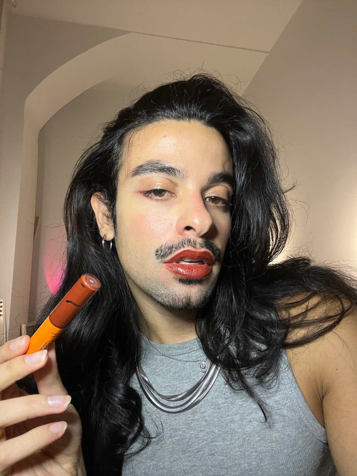 Man wearing Lebubè vegan lip gloss for plump lips in Pomegranate. From Lebubè makeup with skincare benefits, made in Italy