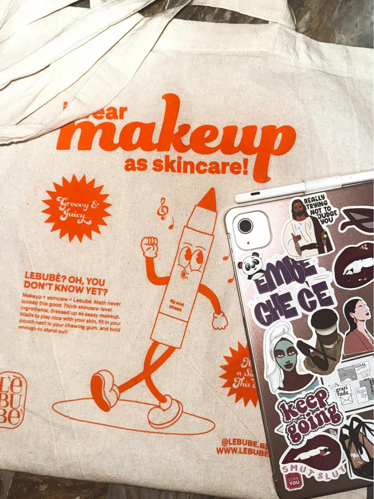 Close up of Lebubè tote bag, 100% natural cotton, “I wear makeup as skincare” orange print
