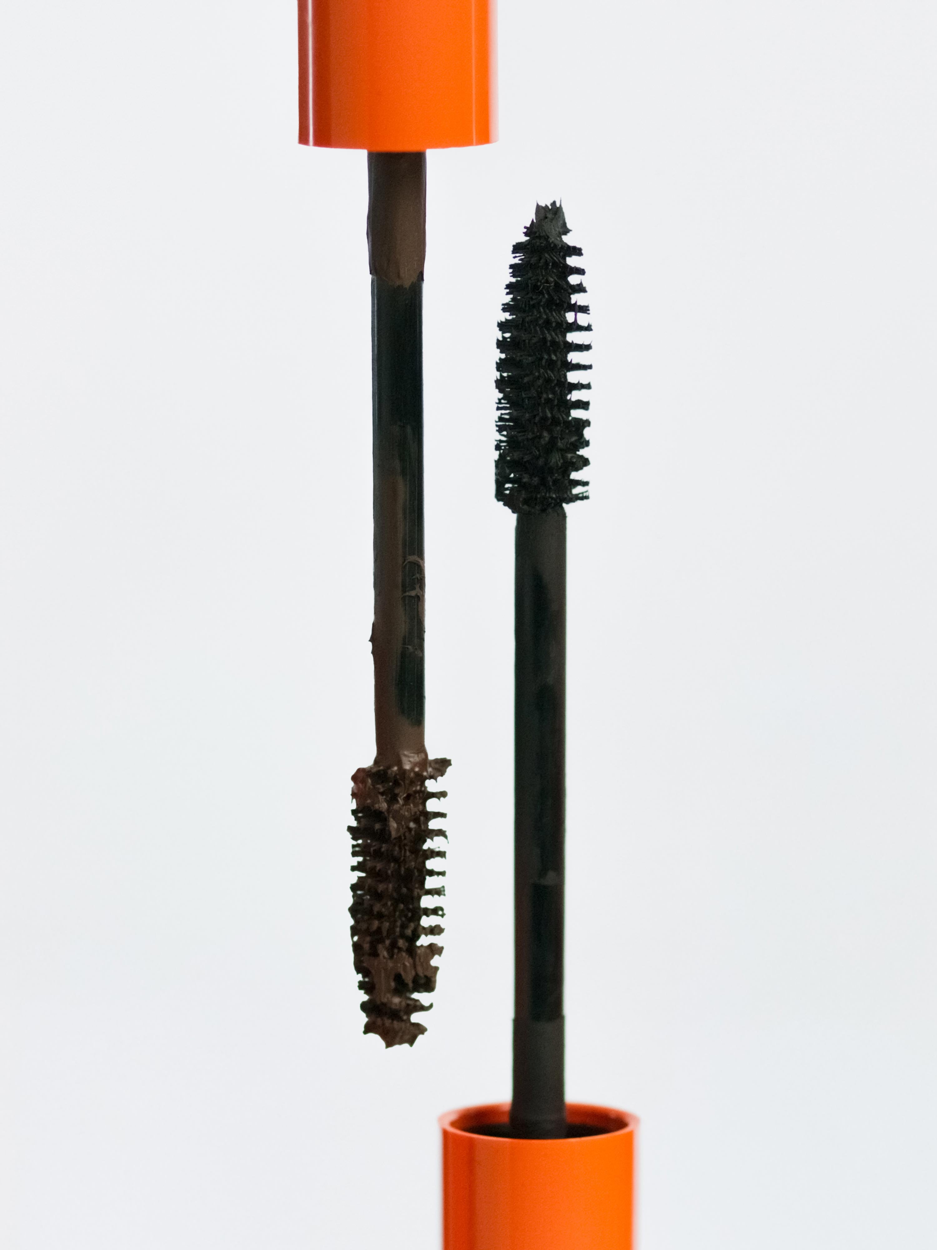 Lebubè plant-based brown and black mascara for naturally defined lashes. Brush zoomed in, resting on the tube. From Lebubè hybrid cosmetics