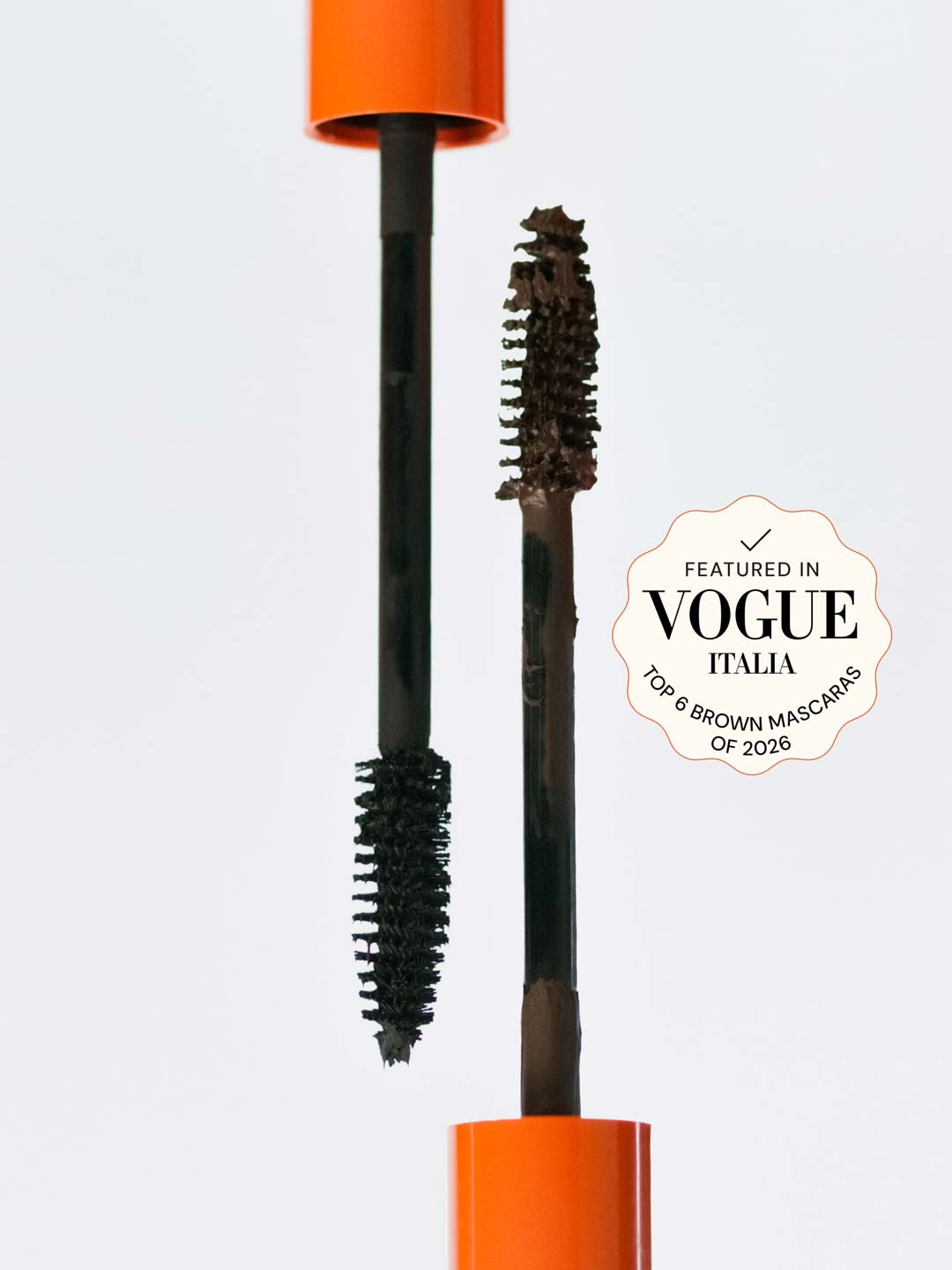 Lebubè plant-based brown and black mascara for naturally defined lashes. Brush zoomed in, resting on the tube. From Lebubè hybrid cosmetics