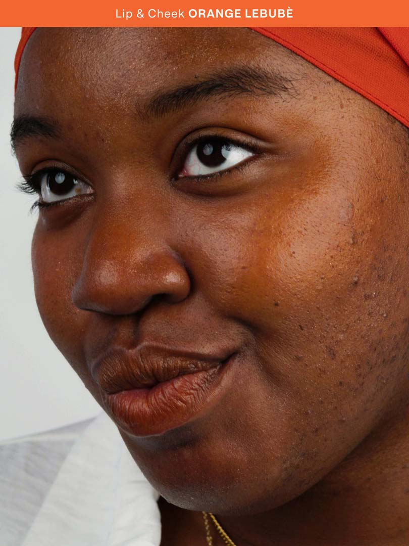 Woman wearing the Halal and vegan Lip and Cheek in Orange Lebubè, the perfect shade for summer and sunset-blush look