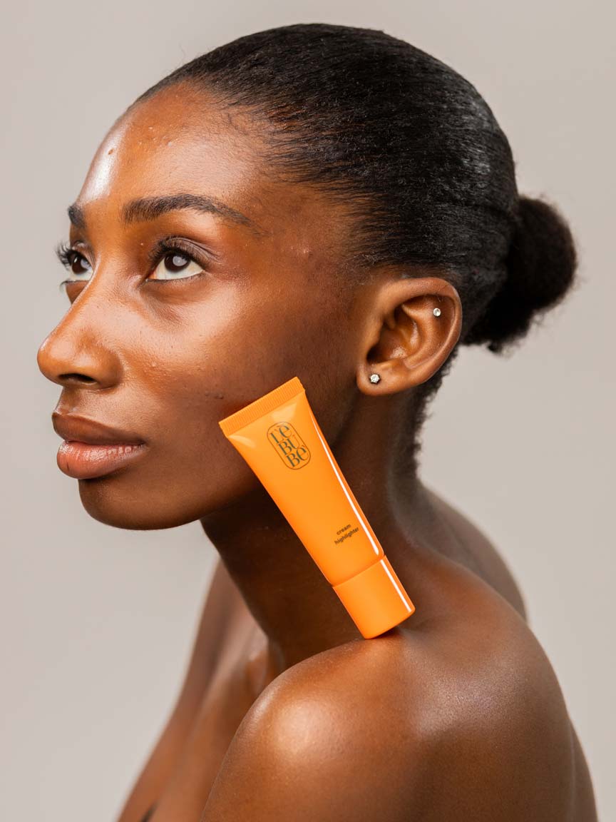 Woman with Lebubè glowing and hydrating highlighter on her face and body, with her skin glowing. From Lebubè natural hybrid cosmetics