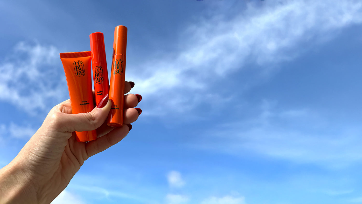 Hand holding Lebubè vegan Halal hybrid cosmetics, inclusive and skincare-infused, in the sky