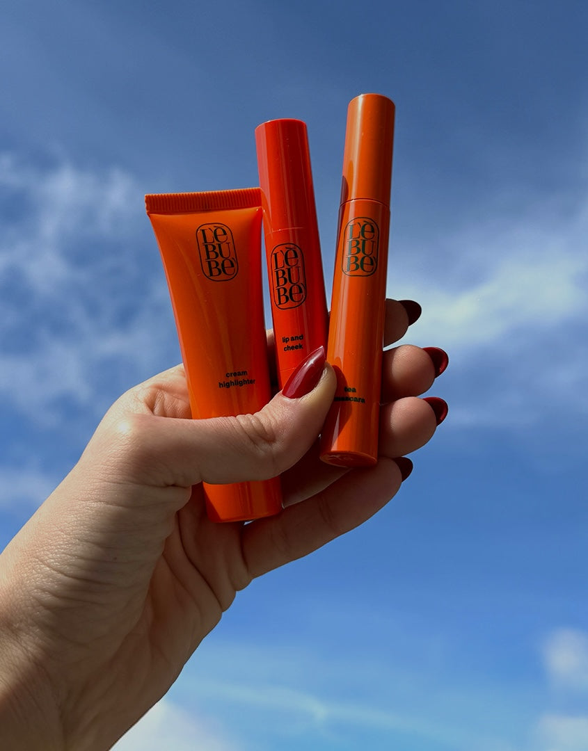 Hand holding Lebubè vegan Halal hybrid cosmetics, inclusive and skincare-infused, in the sky