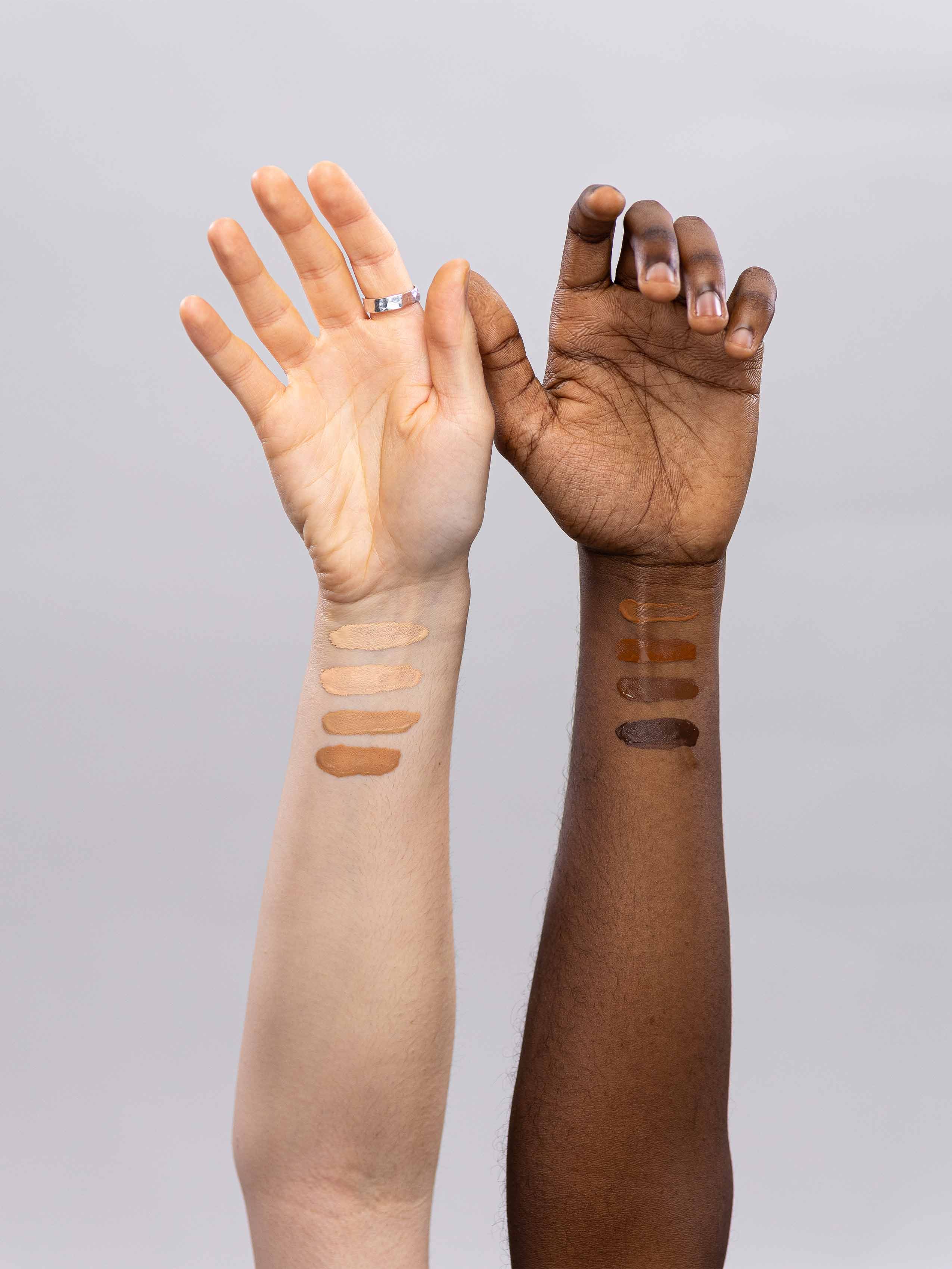 Two arms, one fair & one dark, showing 4 swatches each of Lebubè vegan skin tint in 8 inclusive shades from fair to rich deep