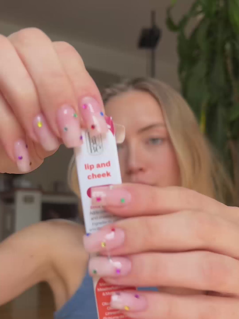 Woman applying Lebubè Lip and Cheek in Rubia Rose, makeup with skincare benefits being a hydrating lipstick and blush in one