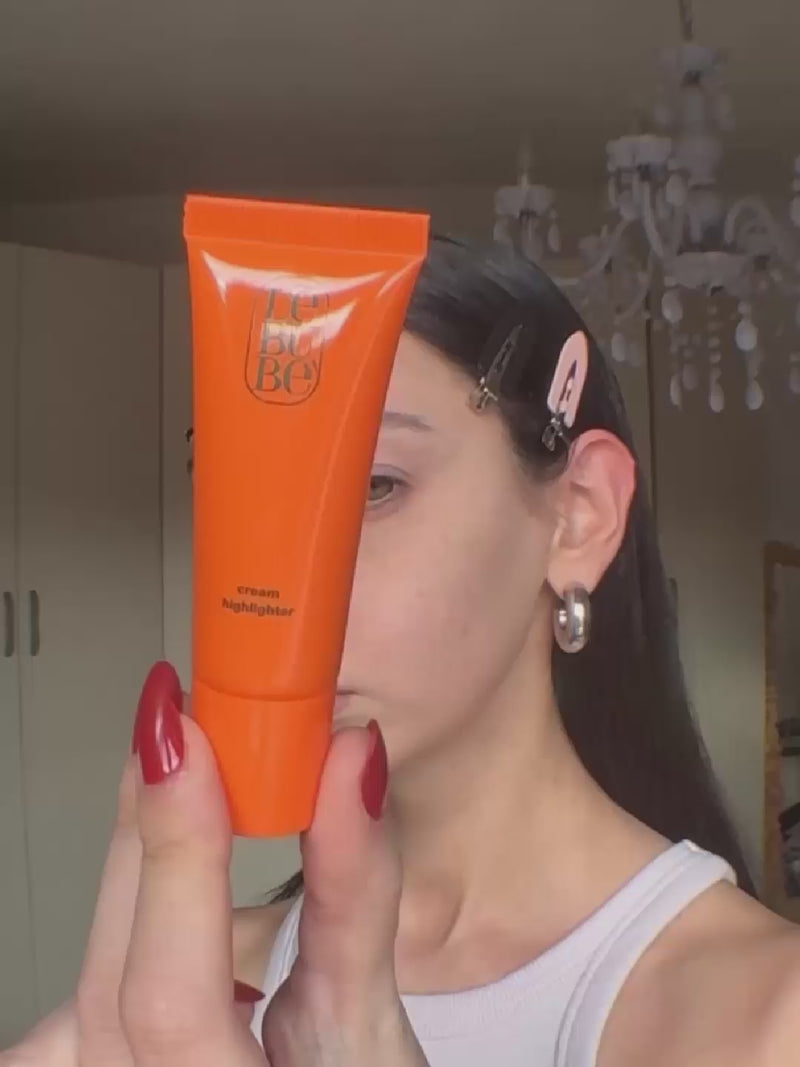 Woman wearing Lebubè cheek hybrid cosmetics: Lip and Cheek, 2 in 1 lipstick and blush, and hydrating cream highlighter