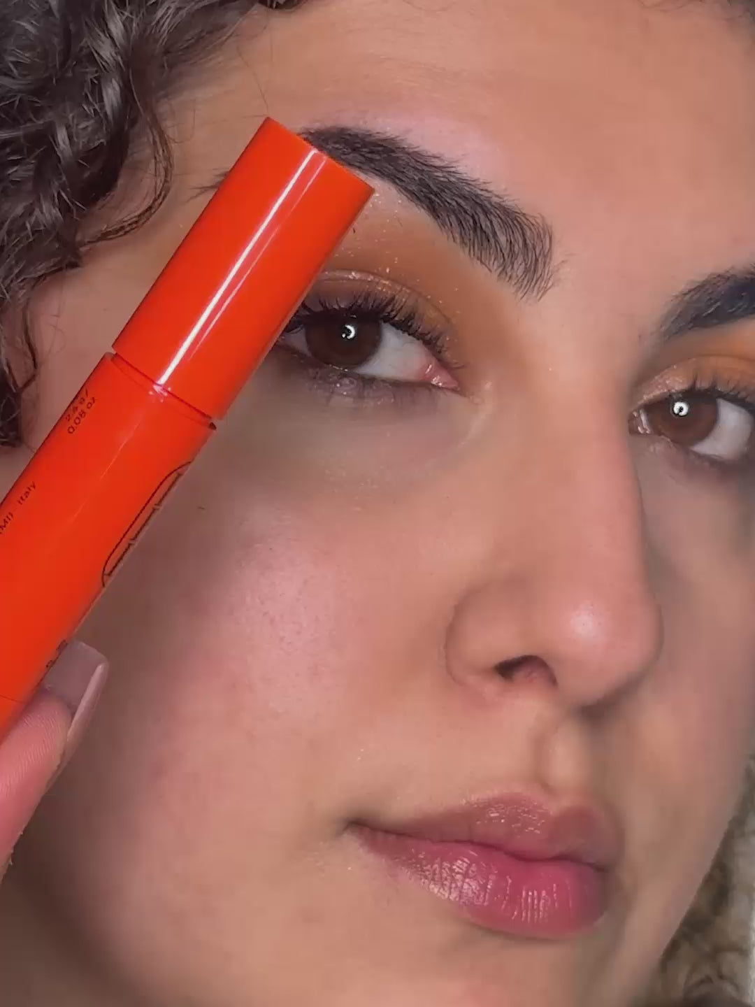 Load video: Woman applying Lip and Cheek in Orange, a lipstick + blush crayon from Lebubè vegan makeup with skincare benefits