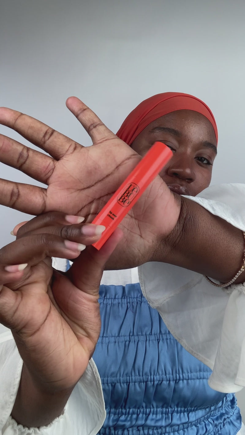 Woman applying Lebubè Lip and Cheek lipstick and blush in Rubia Rose and hydrating cream highlighter for a glowy, dewy effect