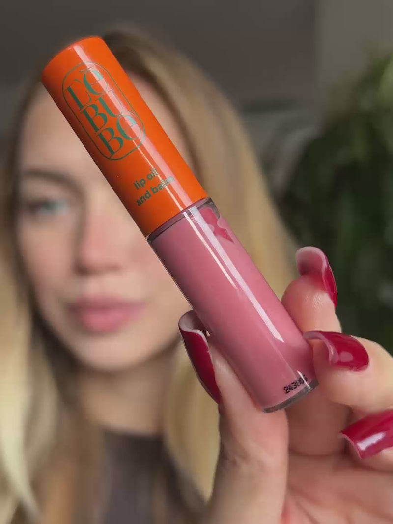 Woman applying the Tinted Lip Oil and Balm in Dalia: a soft pink lip oil with hyaluronic acid for hydration and nourishment