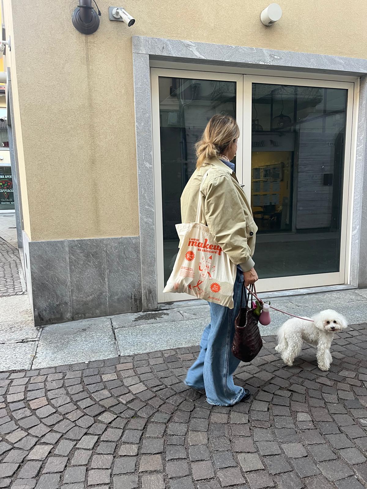 Lebubè tote bag in use, 100% natural cotton, “I wear makeup as skincare” orange print